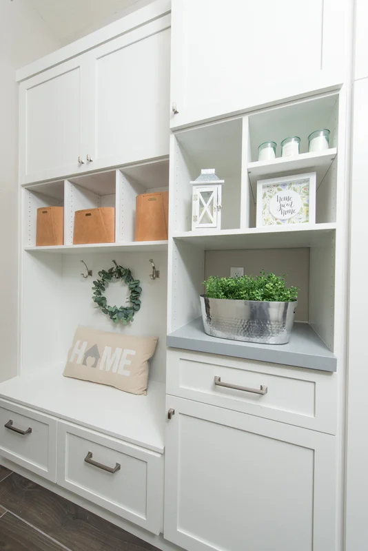 White mudroom with cubbies and decorative storage