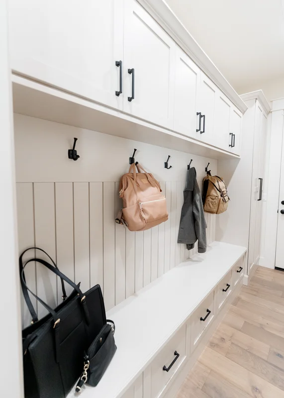 Close-up of mudroom organization with bags and coats