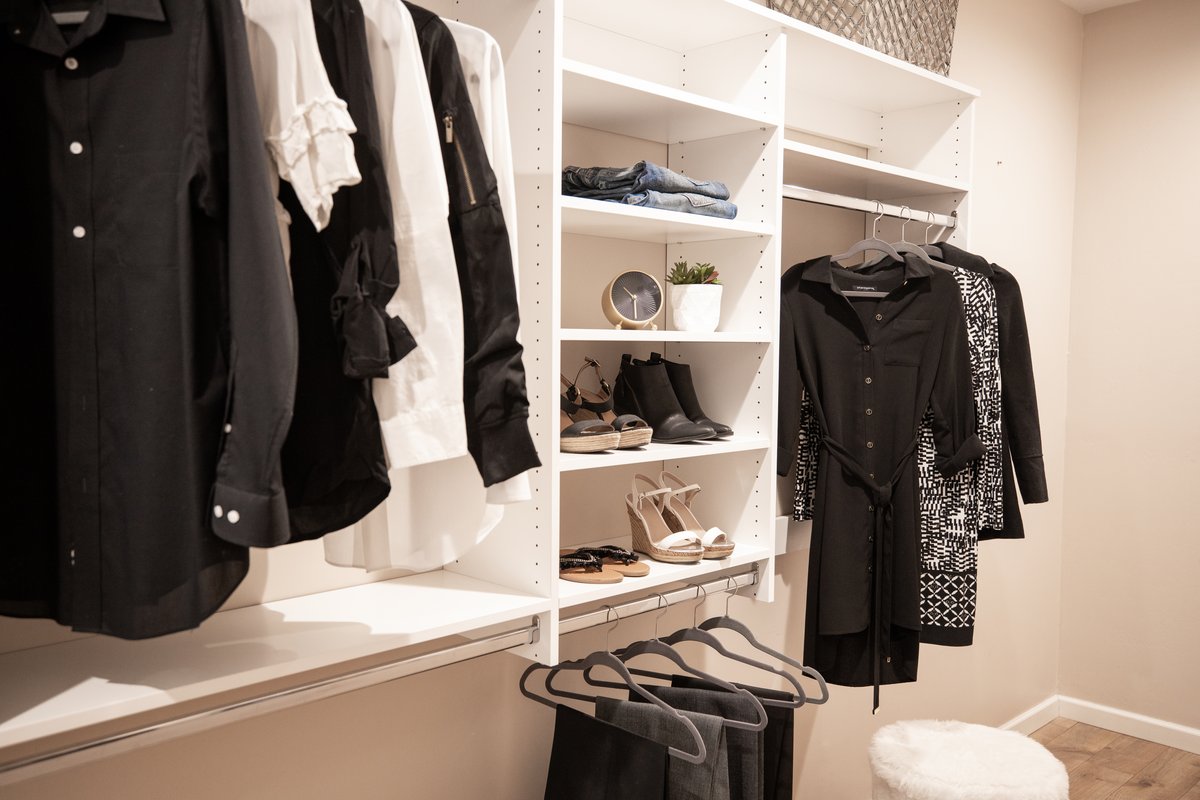 White reach-in closet with shoe storage and hanging rods