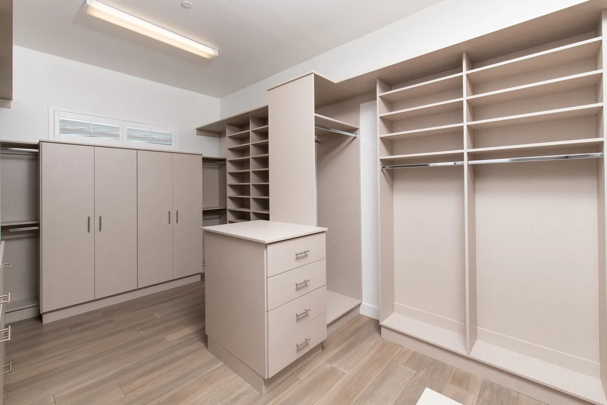 Contemporary walk-in closet with island and multiple hanging zones