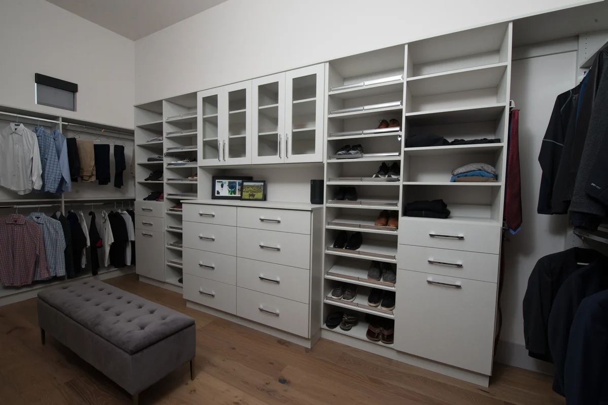Custom walk-in closet with white cabinetry and shoe storage