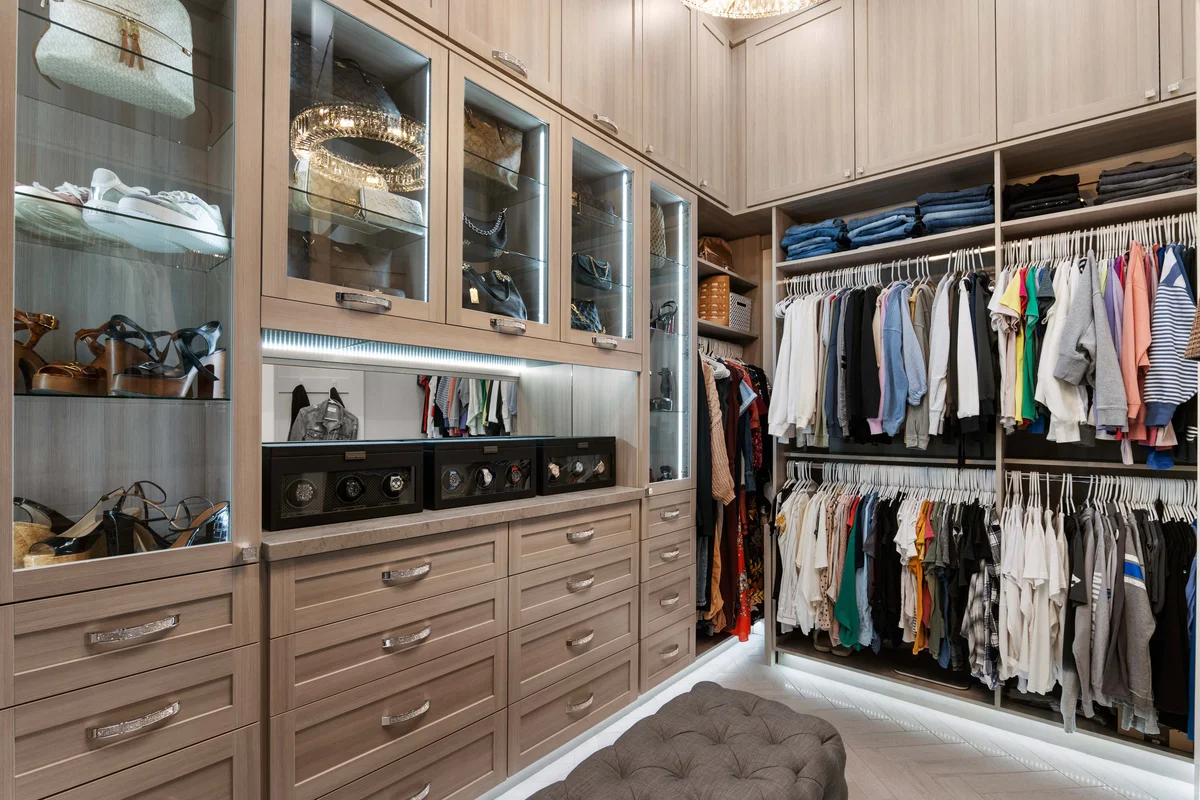 Luxury walk-in closet with glass cabinets and LED lighting