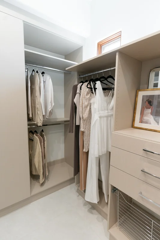 Elegant walk-in closet with neutral tones and custom organization