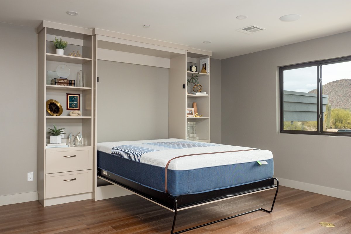 Cream colored wall bed with matching display shelves and mountain views