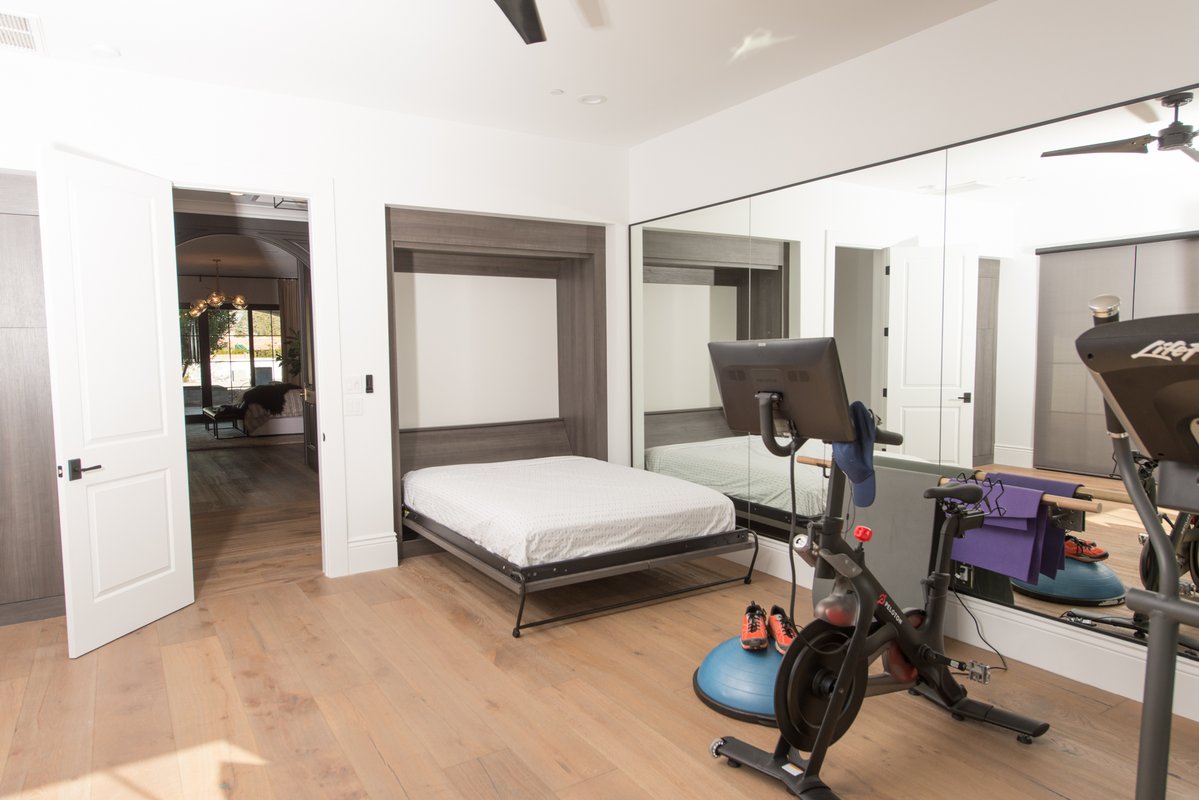 Wall bed in home gym with exercise equipment in modern Arizona home