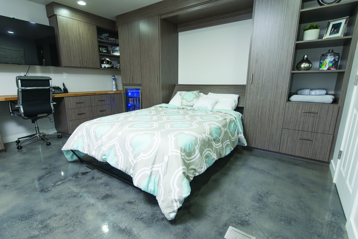 Dark wood Murphy bed with integrated office desk and storage