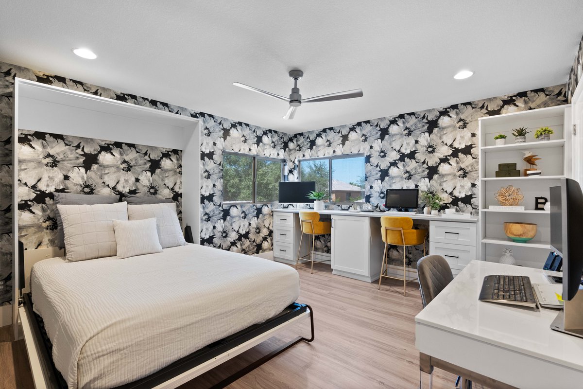 Wall bed in stylish home office with dual workstations and floral accent wall