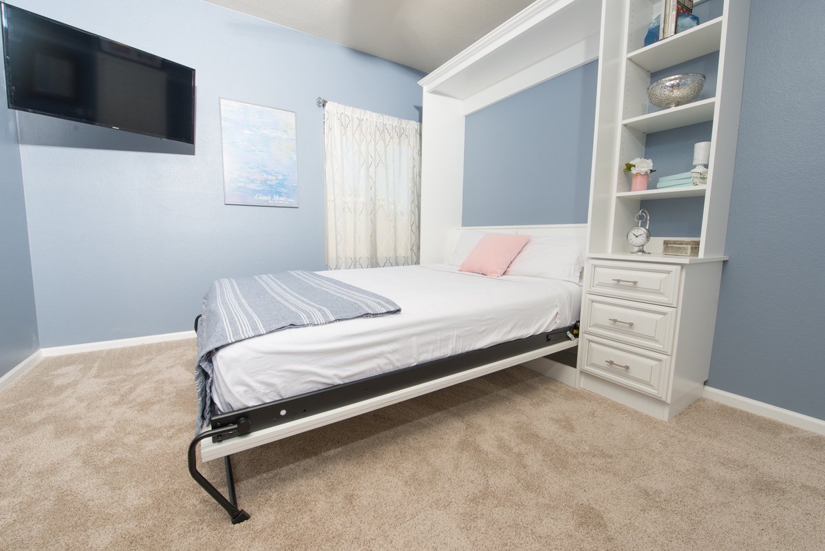 White Murphy bed with built-in shelving and drawers in Paradise Valley home